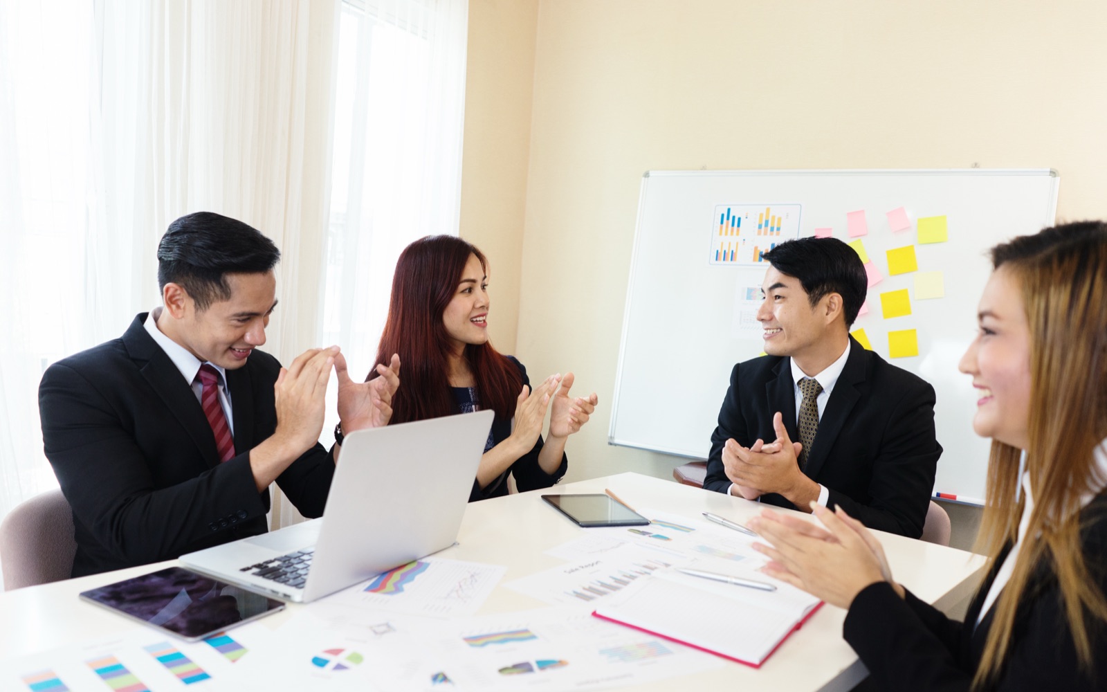 Business team in a meeting beside a whiteboard with sticky notes